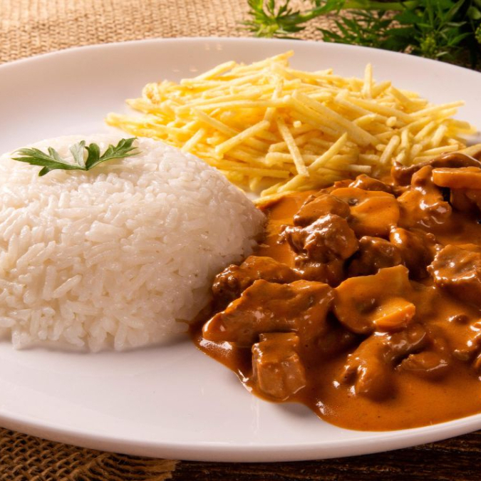 Cubos de carne selecionada envoltos em molho cremoso e temperado na medida certa, servidos com arroz branco e batata palha crocante. Uma combinação que traz aquele gostinho de comida feita com amor.