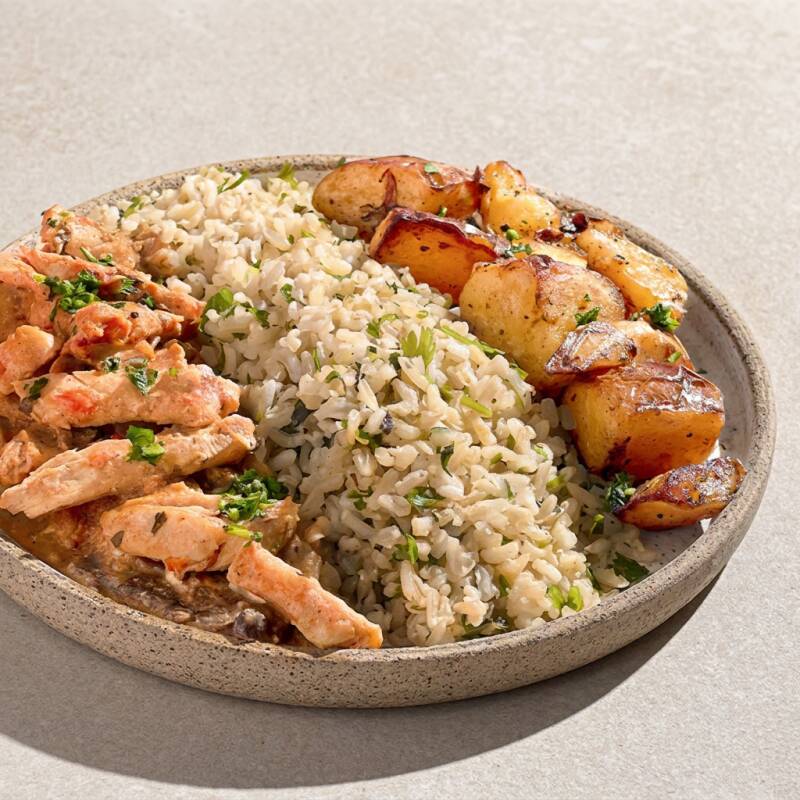 Nosso strogonoff de frango é preparado com ingredientes frescos e selecionados, garantindo um sabor autêntico e inigualável. Acompanhado de um delicioso arroz integral com toques de salsa e batatas rústicas perfeitamente assadas, este prato é a combinação perfeita de sabor e saúde. Uma refeição completa, com 330g, que surpreende não só pelo sabor, mas também pelas leves 275 calorias. Redescubra o prazer de saborear um strogonoff sem qualquer sentimento de culpa!