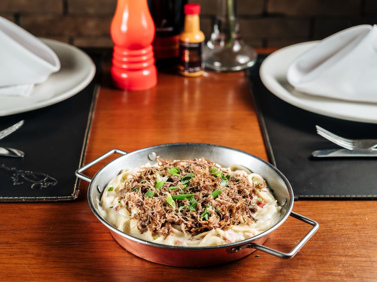 Carne de Sol desfiada grelhada sobre fettuccine com molho alfredo.