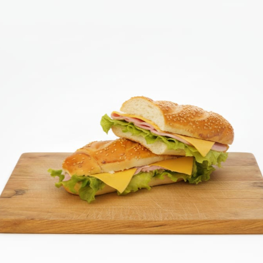 Sanduiche contendo 1 pão com gergelim cortado ao meio, 2 fatias de queijo prato, 2 fatias de presunto, alface e maionese.