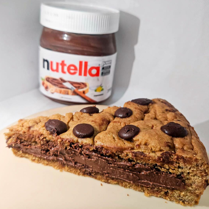 Uma Massa de Cookie Crocante com Gotas de Chocolate 40%, Recheada com Nutella Original.