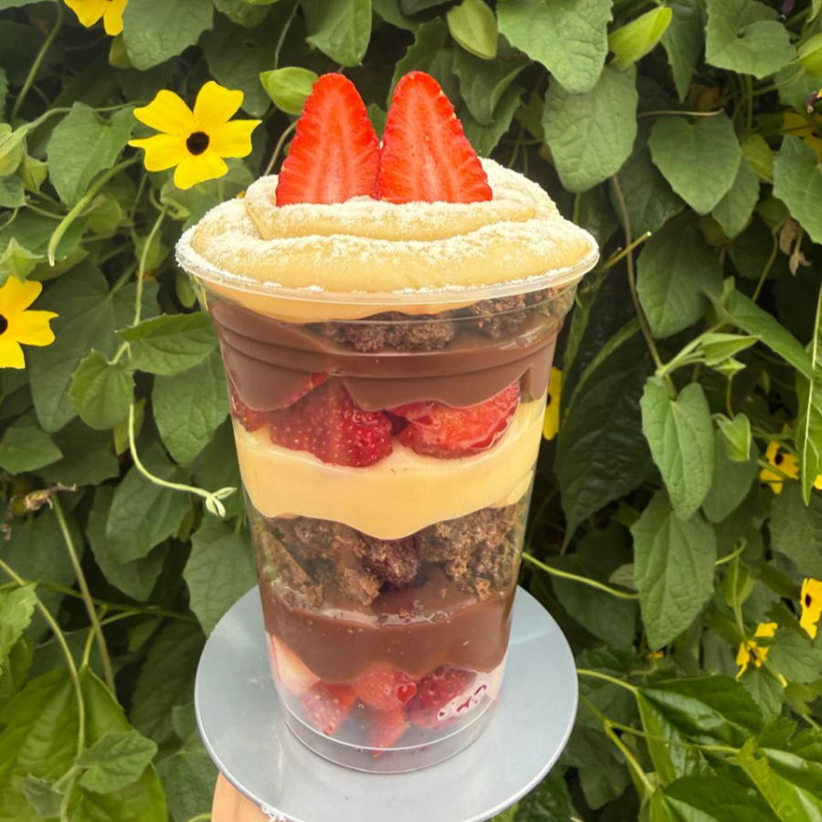 O Copo da Felicidade de Morangos é uma sobremesa dos sonhos! Morangos frescos e suculentos se misturam a camadas generosas de creme de chocolate, creme de Ninho e pedaços macios de Brownie. A combinação perfeita entre o azedinho da fruta, a doçura equilibrada dos cremes e a intensidade do brownie cria uma explosão de sabor e textura a cada colherada. Uma verdadeira tentação para os amantes de doces!