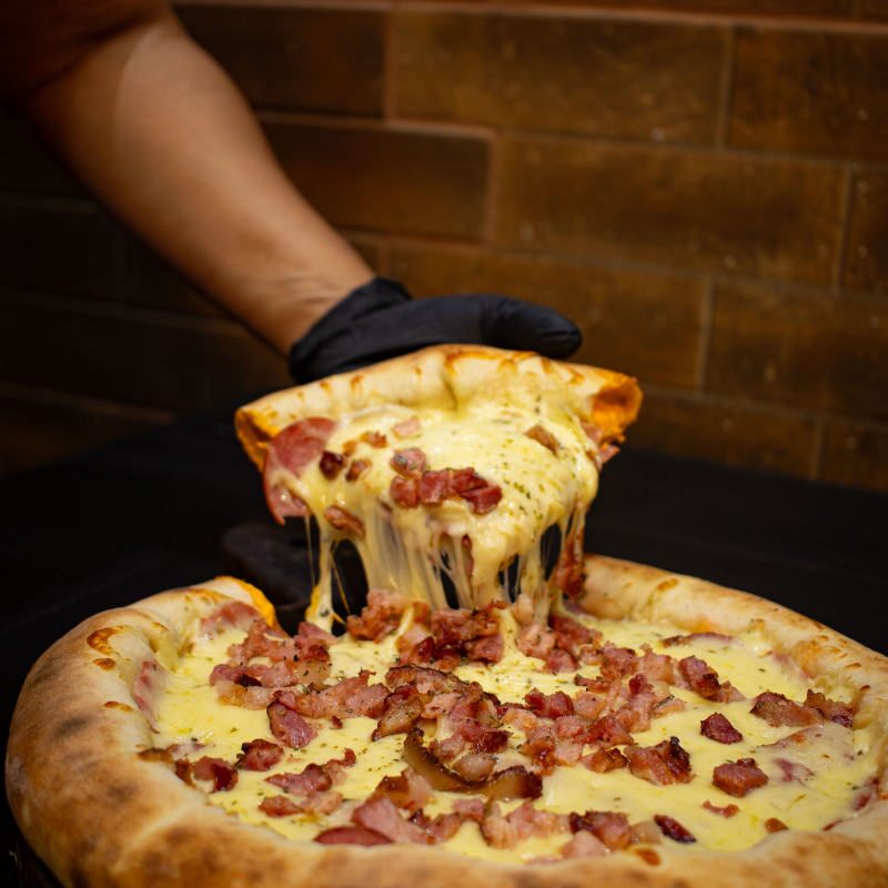 Dois sabores que deixa uma sensação de sabor inesperadamente incrível. Com muita calabresa, bacon e mussarela de um lado e a queridinha do outro lado. Calabresa vai: mussarela, calabresa, cebola e orégano. Á Moda : mussarela, presunto, calabresa, bacon, cebola, pimentão, milho e orégano