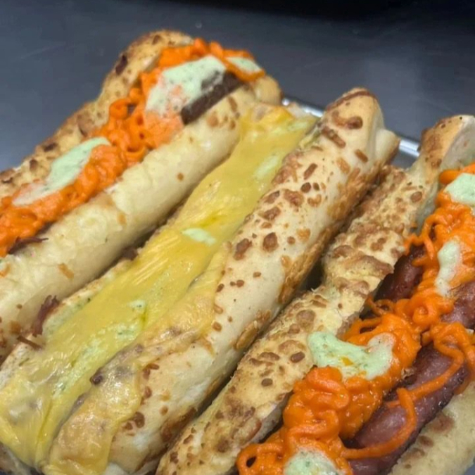 Baguete com queijo parmesão, creme de alho, maionese da casa, hambúrguer 180g com bacon picado e queijo de sua escolha. Aproximadamente 15cm, podendo variar.