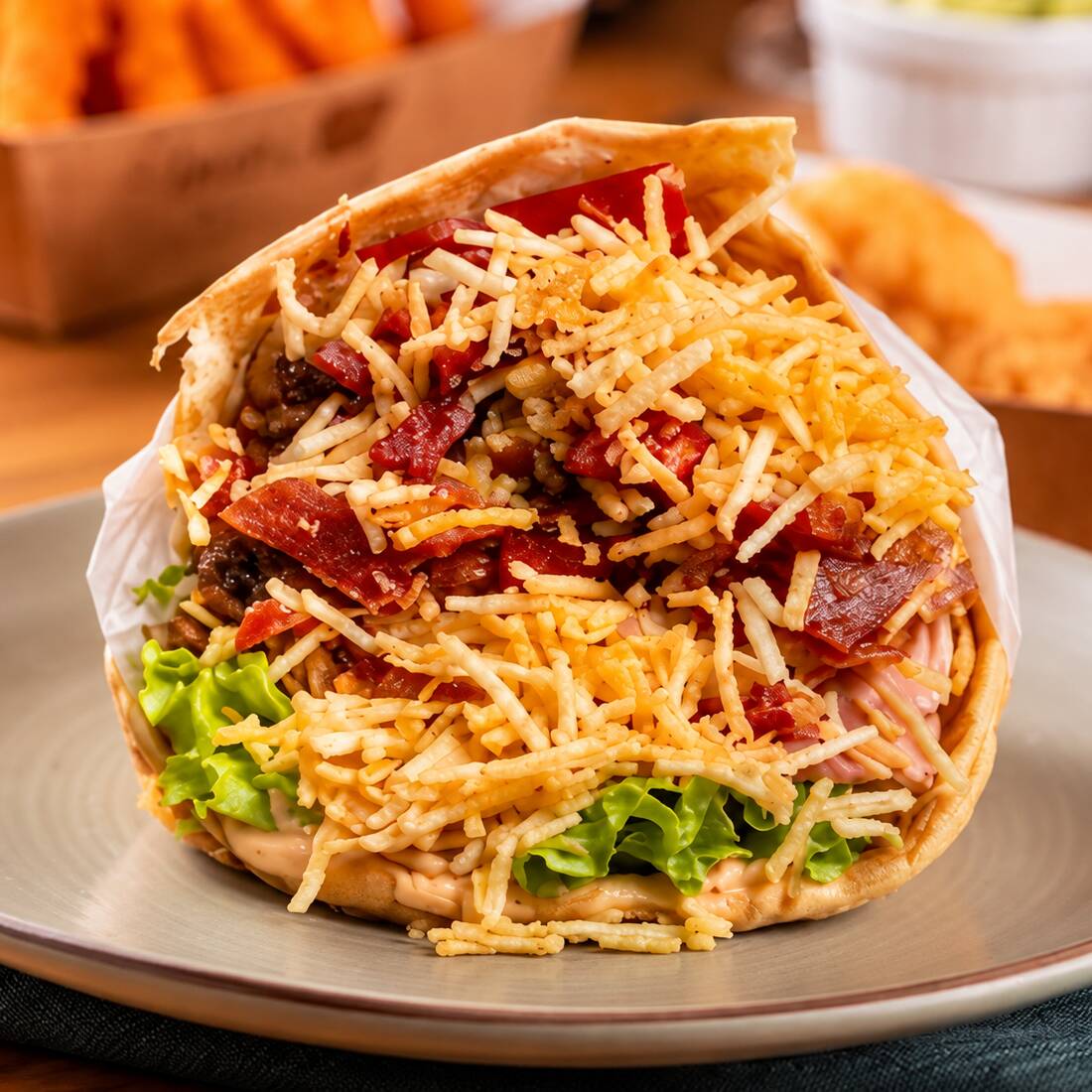Pão com burguer(100g), muçarela, bacon crocante, ovo, tomate, alface, milho e batata palha. Um lanche completo, bem recheado e cheio de sabor.