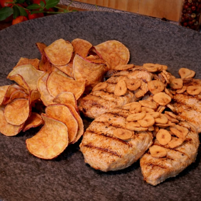 Escalopes de frango com lâminas de alho (aprox. 180g para 1 Pessoa, 360g para 2 Pessoas e 540g para 3 Pessoas, carne in natura). Acompanha arroz branco, farofa de ovos e chips de batata doce.