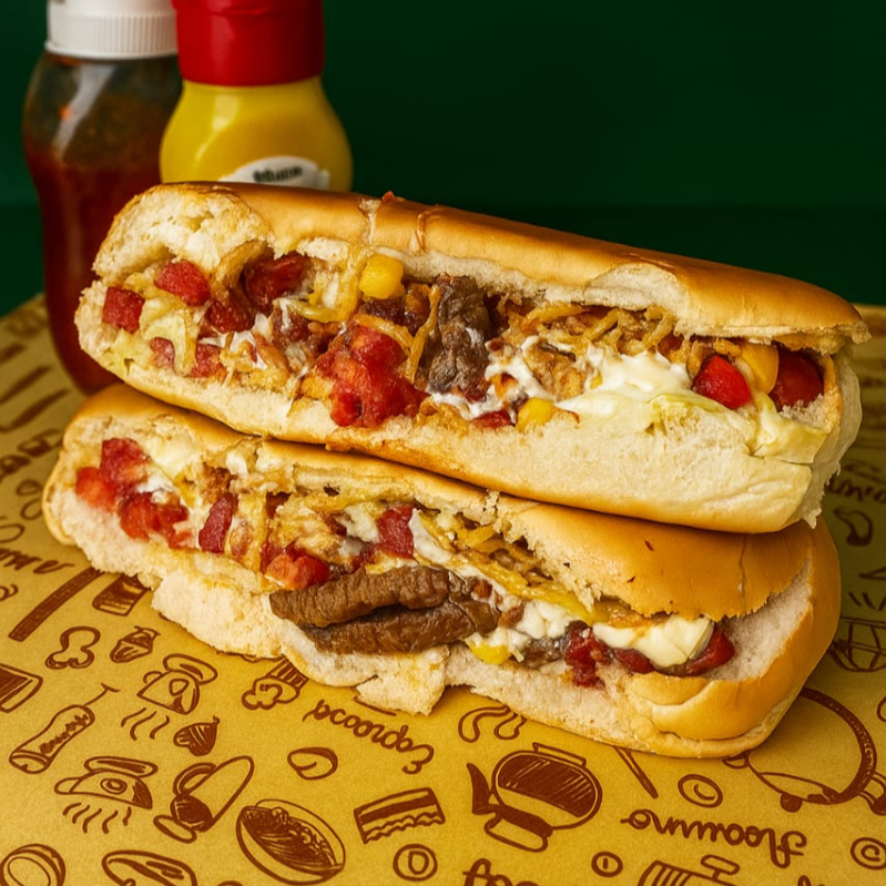 Dois Pão especial recheado com duas salsichas, tomate, milho, maionese caseira, alcatra, bacon, cream cheese, catupiry e batata palha. Uma combinação saborosa e irresistível para os amantes de um bom lanche.