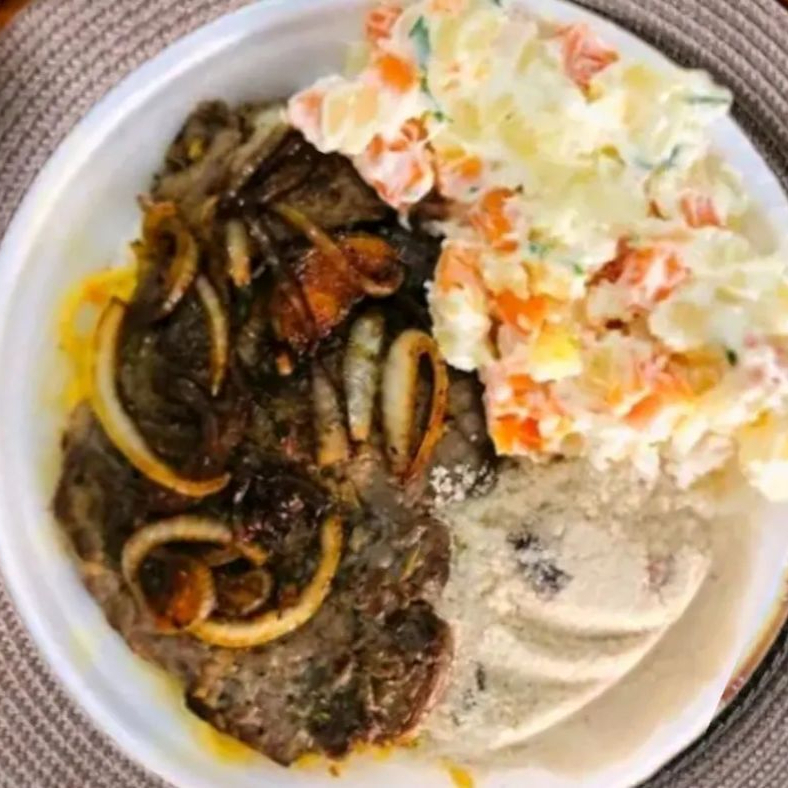 O contra filé acebolado é um prato clássico e delicioso da gastronomia brasileira. Preparamos o suculento contra filé grelhado, acompanhado de generosas fatias de cebola dourada, que conferem um sabor único e irresistível à carne.  Utilizamos cortes selecionados de contra filé, garantindo a maciez e suculência da carne. Grelhamos cuidadosamente, mantendo todo o sabor e suculência da carne, enquanto a cebola é preparada delicadamente para adicionar um toque de doçura ao prato. Acompanhando de arroz feijão macarrão farofa.