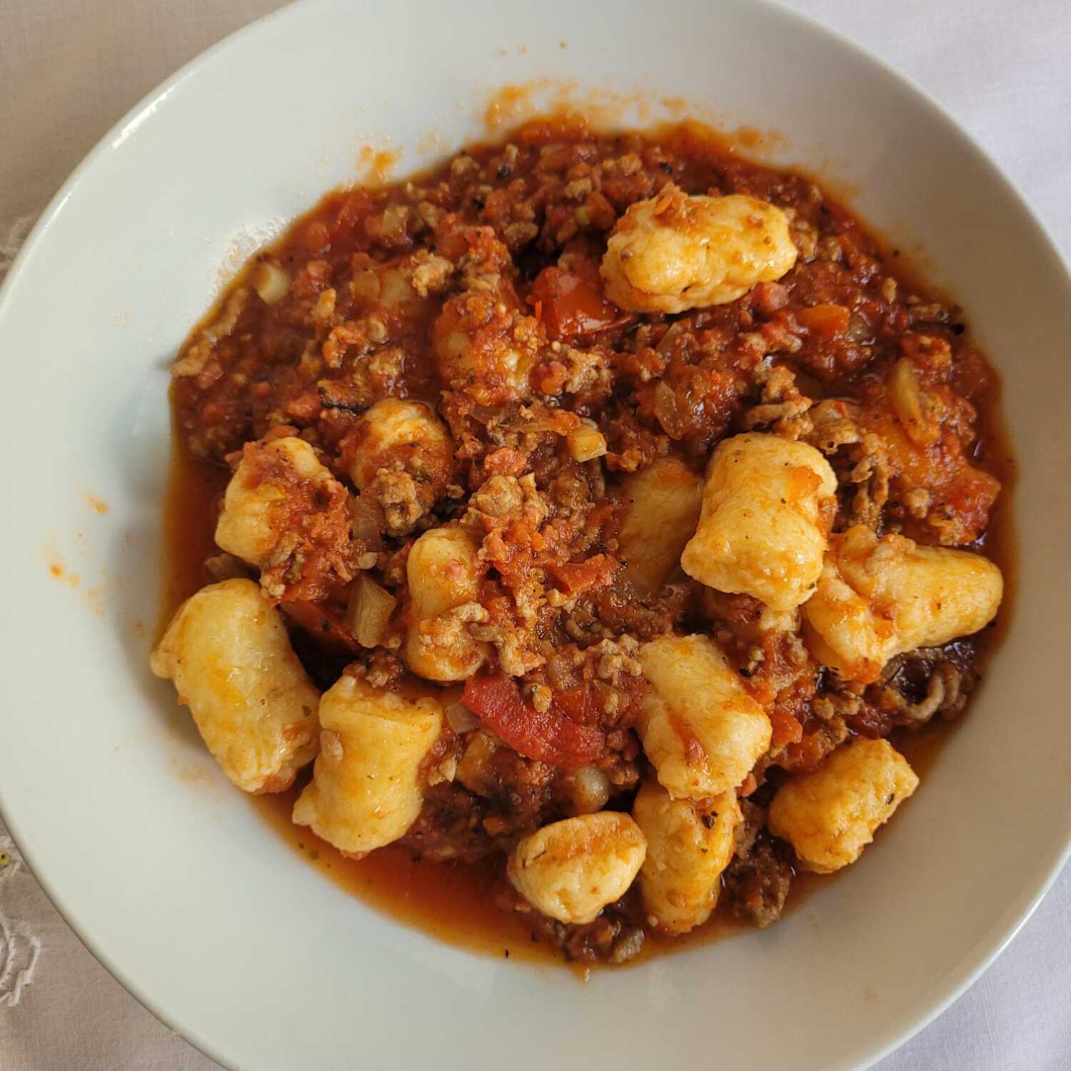 Acompanha um delicioso nhoque com carne moída, queijo ralado e arroz