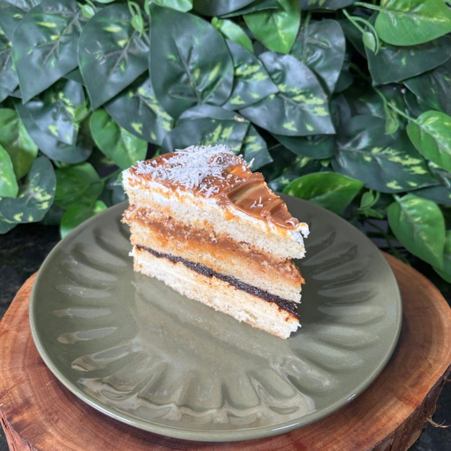 Essa fatia pra mim é total memória afetiva. Me lembra infância, aconchego, nossa fatia Nostalgia. Bolo de baunilha molhadinho, recheado com doce de leite, ameixa e creme de coco. Com cobertura de uma fina camada de chantinho e doce de leite.