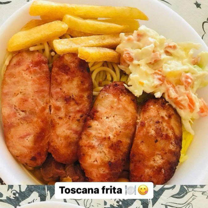 Linguiça toscana frita, bem dourada e suculenta, preparada na hora, acompanhada de arroz, feijão, macarrão, salada, farofa e batata frita.