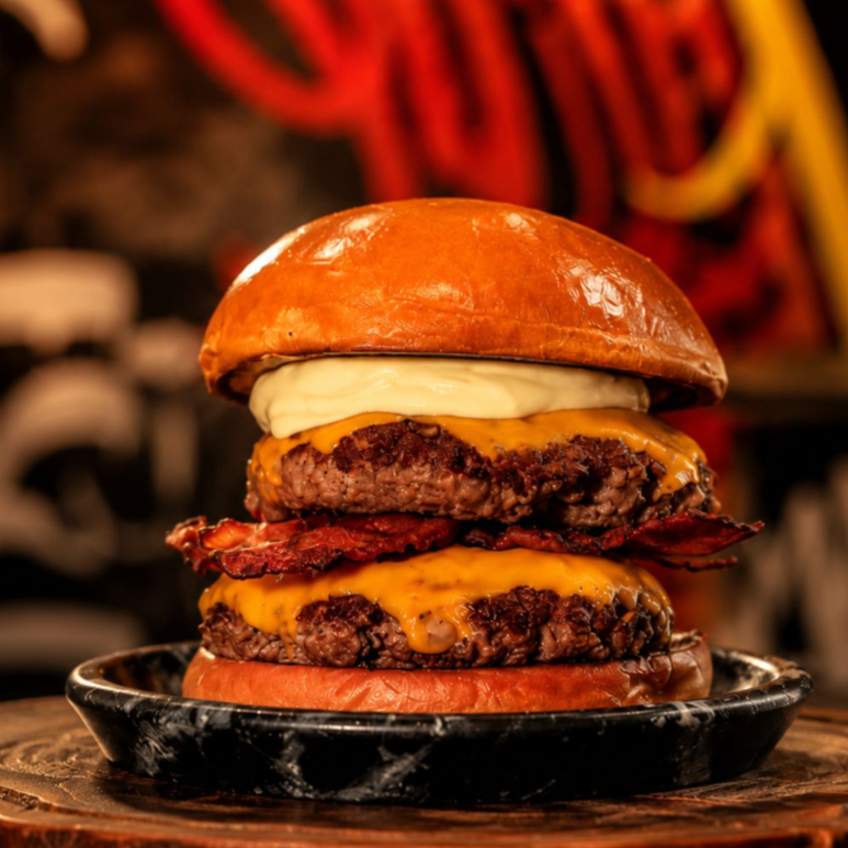Pão de hamburguer, duas carnes angus de 150g (300g total) dobro de queijo, dobro de bacon e maionese D'Bronx