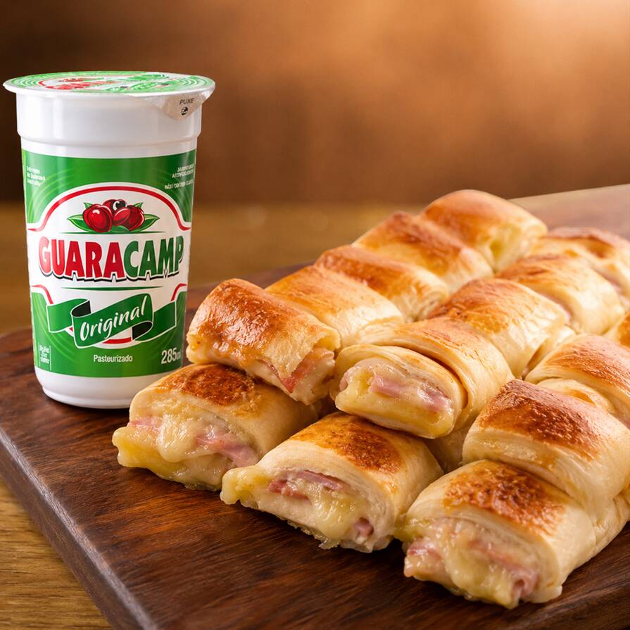 1 pct c/6 uni Mini Joelho de Frios (Pão super macio, recheado com uma combinação irresistível de mussarela, presunto, requeijão cremoso, mortadela, milho e um toque de cheiro-verde. Sabor e maciez em cada mordida - aprox. 150g).+ 1 Guaracamp 285ml. Perfeito para um lanche rápido e gostoso.