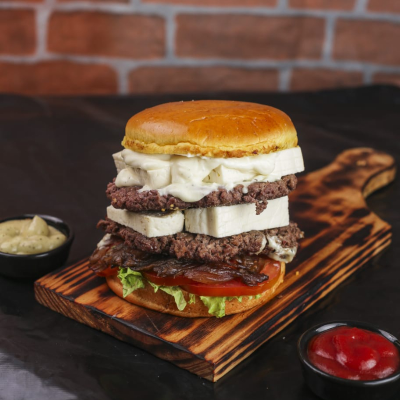 Pão bola, Dupla carne artesanal tostada na chapa, Dupla porção de queijo coalho derretido em cima da carne, alface fresquinho do Dia , tomate salada, cebola caramelizada ao shoyo, e por fim dupla camada de maionese cremosa artesanal.