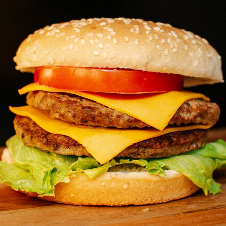 Pão grande , duas carnes bovinas de 90g , queijo cheddar, alface americana e tomate.