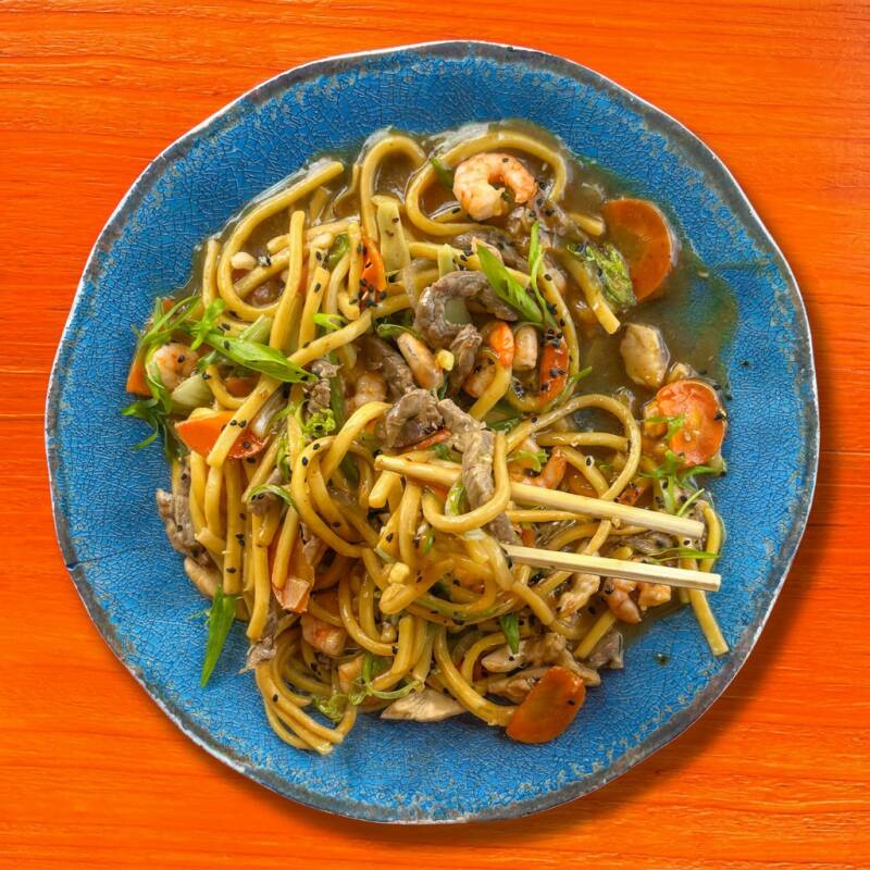 Yakisoba com frango, carne e legumes frescos salteados no molho oriental. Sabor e tradição em cada garfada! (Aprox. 400g)