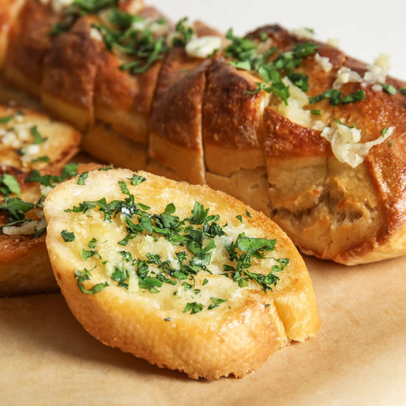 Três mini baguetes de pão de alho, crocantes e saborosas, ideais para acompanhar qualquer refeição.