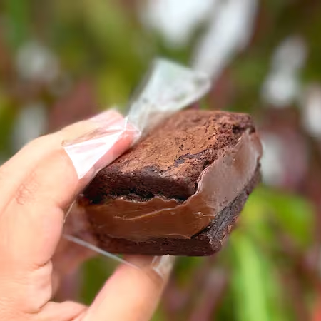 Brownie artesanal super macio, com casquinha por fora e recheio cremoso de chocolate que derrete a cada mordida. Uma explosão de sabor para os apaixonados por chocolate! 🤎