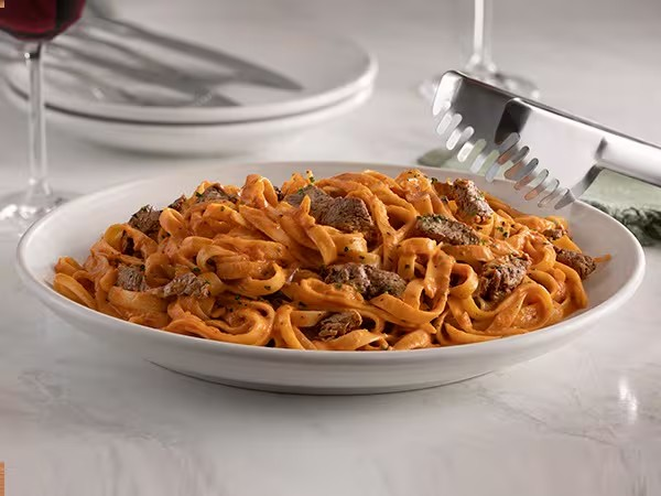 Massa fettuccine envolvida em uma deliciosa combinação dos molhos Alfredo e Pomodoro, servida com tiras de filet mignon.
