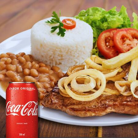 Bife acebolado suculento com cebolas caramelizadas, servido com arroz temperado, feijão caseiro, fritas crocantes e salada fresca. Sabor caseiro que conquista!