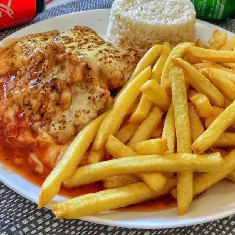 Arroz, parmegiana de frango acompanhada com batata frita e salada