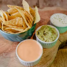 Delicie-se com a nossa generosa 'Porção de Nachos ', perfeita para compartilhar. Esta requintada porção, é composta por crocantes e autênticas tortilhas chips de milho, também conhecidas como 'totopos'. Acompanha um trio de irresistíveis molhos: o fresco e saboroso Guacamole, o riquíssimo Cheddar derretido e o cremoso Sourcream. Uma combinação perfeita para desfrutar em qualquer ocasião.