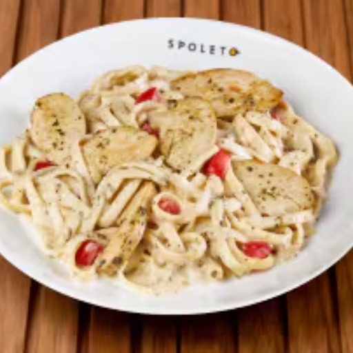 Fettuccine ao molho branco e molho pesto, com tomate em cubos, queijo parmesão, manjericão e tiras de frango.