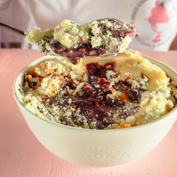 Porção de açai servida com banana, granola, leite em po e leite condensado. tamanho da embalagem 300ml