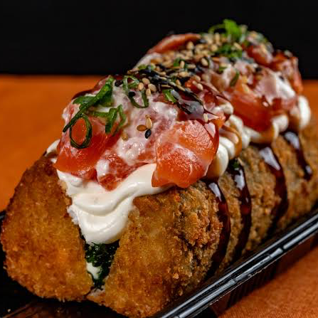 Arroz empanado, recheado com salmão, cream cheese finalizado com cebolinha, teriaki e gergelim