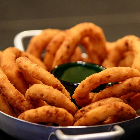 10 Cebola Crocante Empanada, Servida com Molho Verde Especial da Casa. Um Petisco Perfeito para Acompanhar e Compartilhar.
