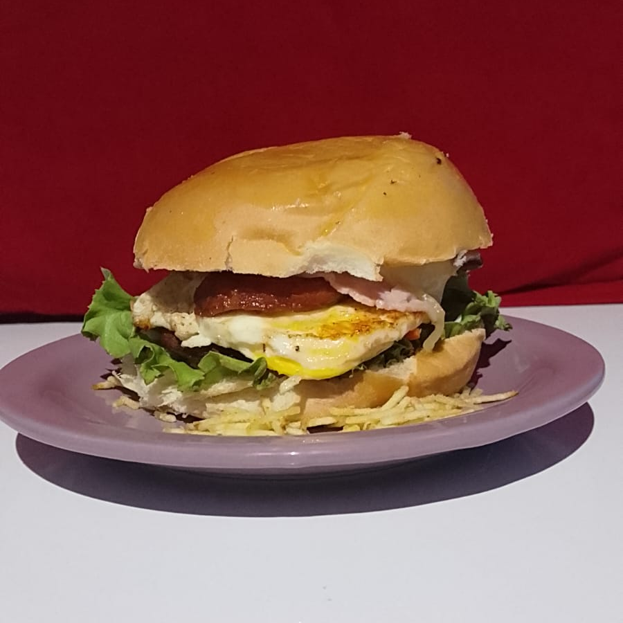 Pão amanteigado, carne, ovo, calabresa, salada, queijo, presunto, milho e ervilha.