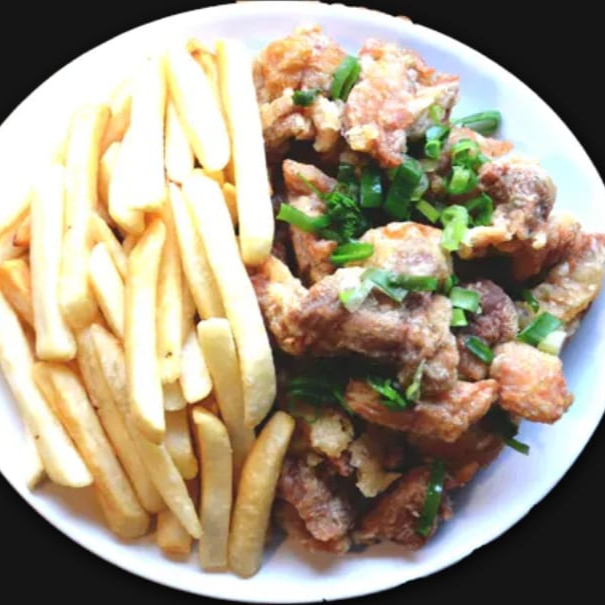 pedaço coxa desossada frita salpicada com alho e cebolinha mais batata frita.