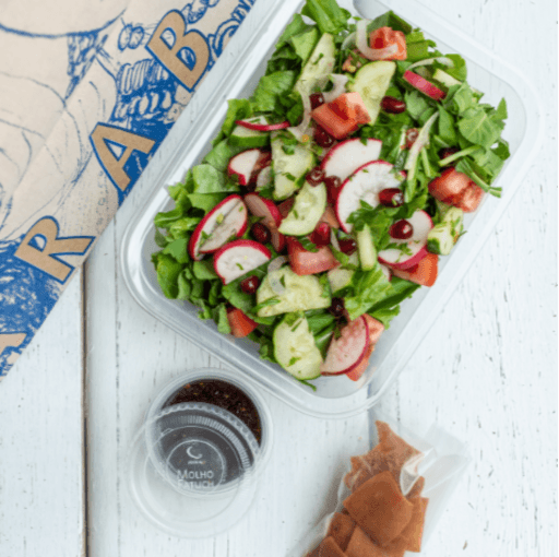 Vegano - A mais vendida! Mix de folhas verdes (rúcula, alface americana, salsinha e hortelã fresca), tomate, pepino, rabanete e cebola picados, pão libanês frito e sementes de romã. Acompanha molho agridoce com melaço de romã, azeite extra virgem, limão e sal.