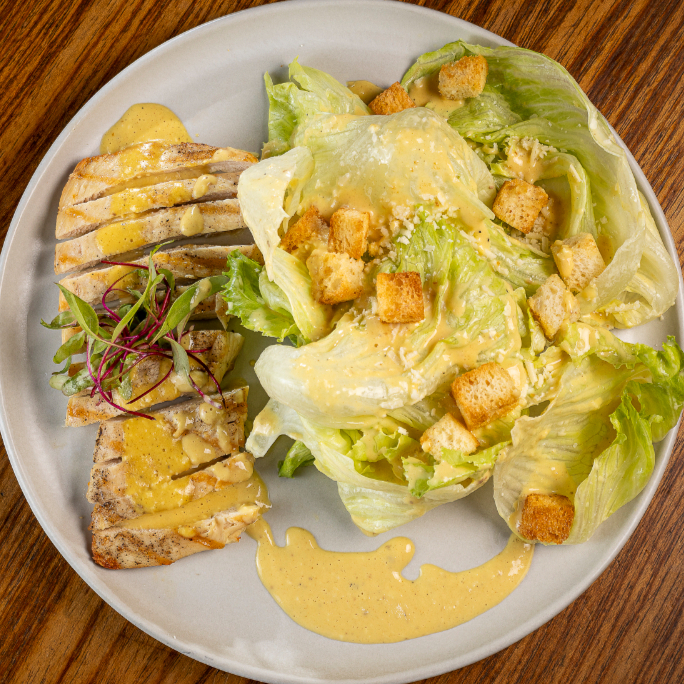 Alface americana, croutons no azeite de ervas, parmesão e molho caesar com filé de frango grelhado.