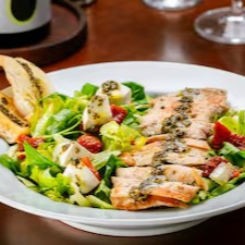 Mix de alface e rúcula, tomate seco, muçarela de búfala, frango grelhado, torradas e pesto.