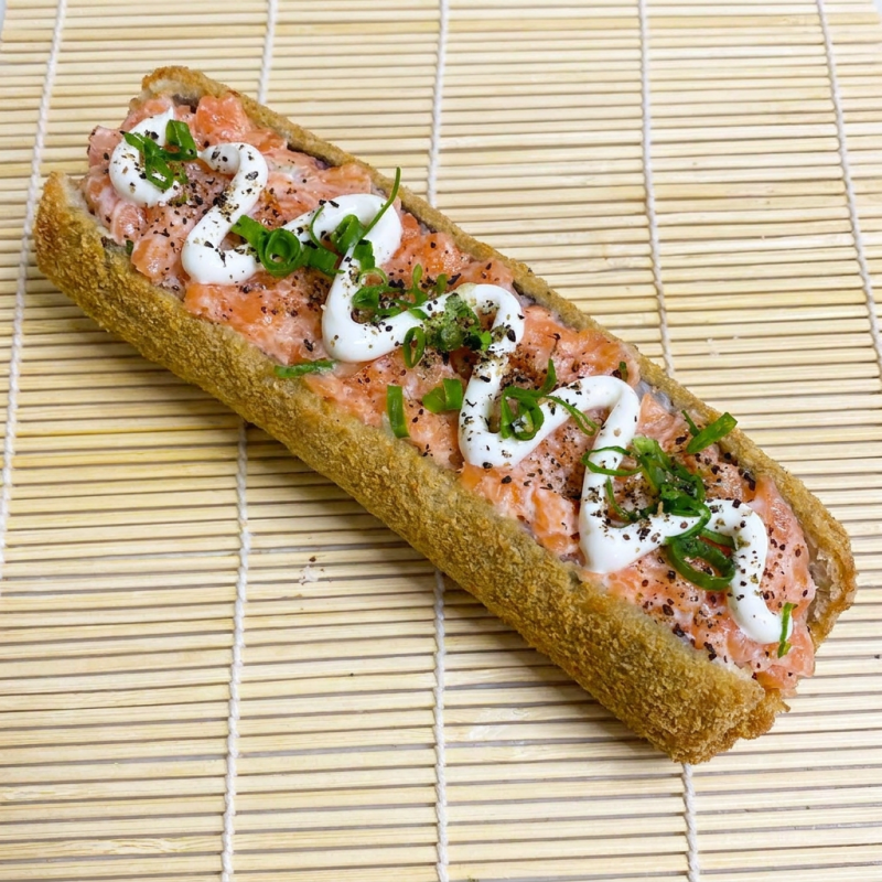 Enrolado crocante recheado de salmão cru com cream cheese, cebolinha e gergelim.