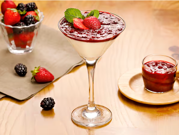 Sobremesa à base de creme de leite, finalizada com calda de frutas vermelhas, morangos frescos e hortelã.