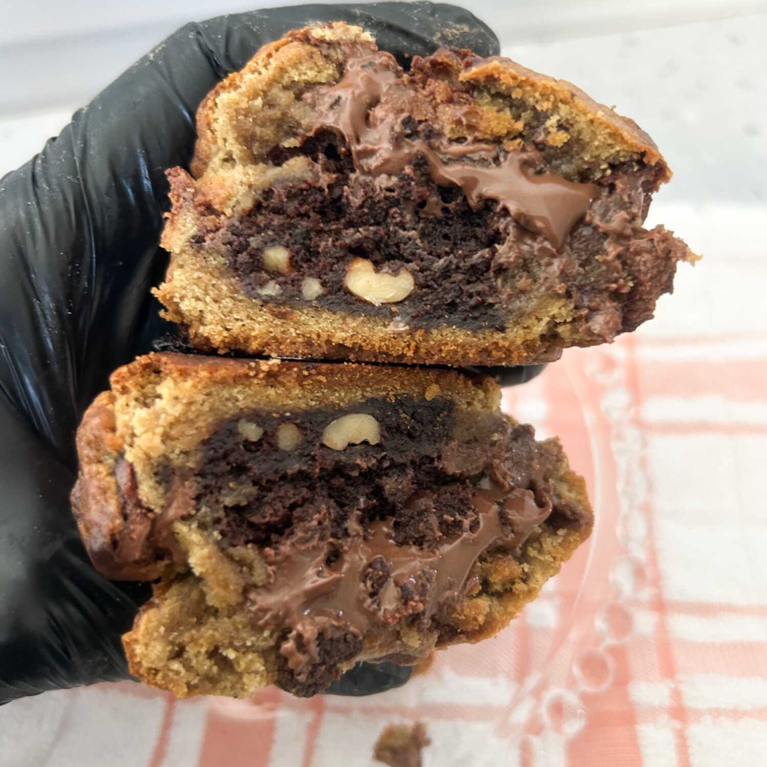 Massa tradicional de cookie com generosas gotas de chocolate, recheada com brownie de chocolate com nozes e um irresistível creme de Nutella. Crocante por fora, macio por dentro e com um recheio intenso que conquista os amantes de chocolate. 🍪🍫🌰