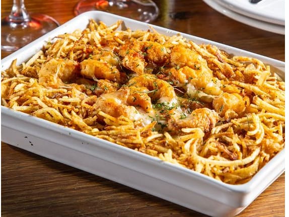 Arroz à grega (ervilhas, pimentões, passas, cenoura e presunto) coberto com de camarões à milanesa, molho caseiro de tomate fresco. Gratinado com queijo mussarela. Acompanha batata palha. (*) a quantidade de pessoas que cada prato serve é apenas uma