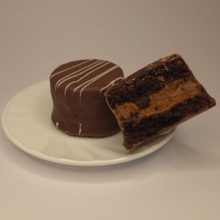 Massa super fofinha com toque de especiarias, recheada generosamente com um cremoso doce de leite e finalizada com uma casquinha crocante de chocolate ao leite. Equilíbrio perfeito a cada mordida!