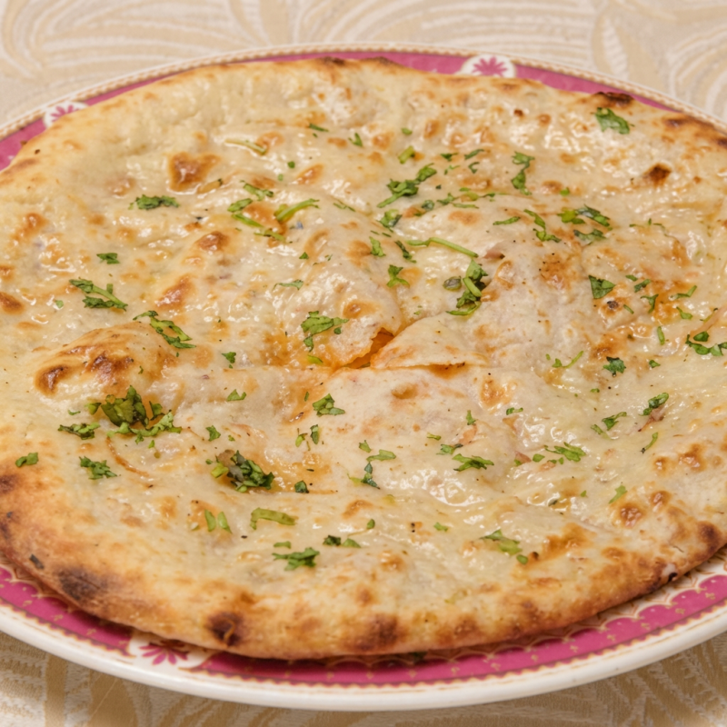Pão indiano assado no forno tandoor com cebola. (massa feita de trigo e iogurte)