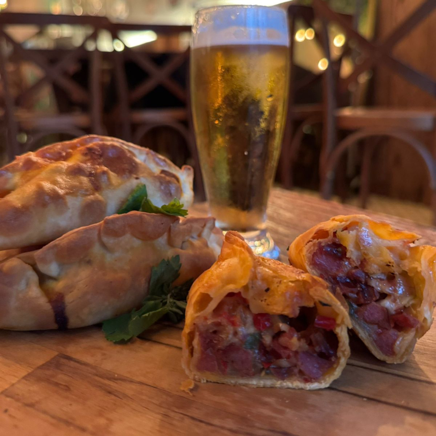 Empanada com recheio generoso de linguiça calabresa, bacon, cebola, pimentão, e muçarela