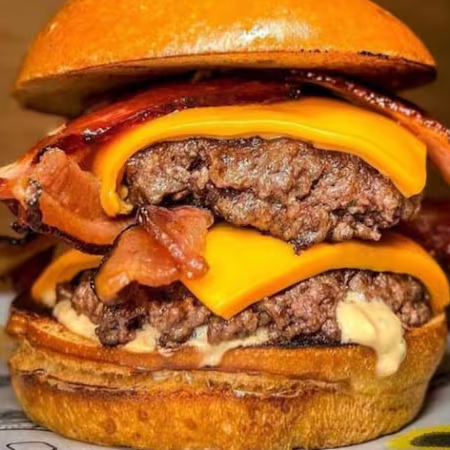 Duplique o prazer com nosso hambúrguer: dois suculentos hambúrgueres bovinos de 140g, bacon crocante, queijo cheddar duplo e molho especial, entre pães de brioche. É a celebração definitiva do sabor para os verdadeiros amantes de hambúrguer.