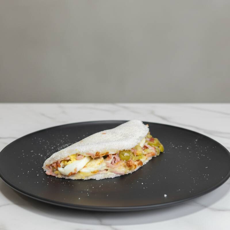 Tapioca recheada com queijo muçarela, presunto, tomate, cebola, azeitona e ovo cozido, finalizada com uma pitada de orégano. Uma combinação clássica, bem recheada e cheia de sabor.