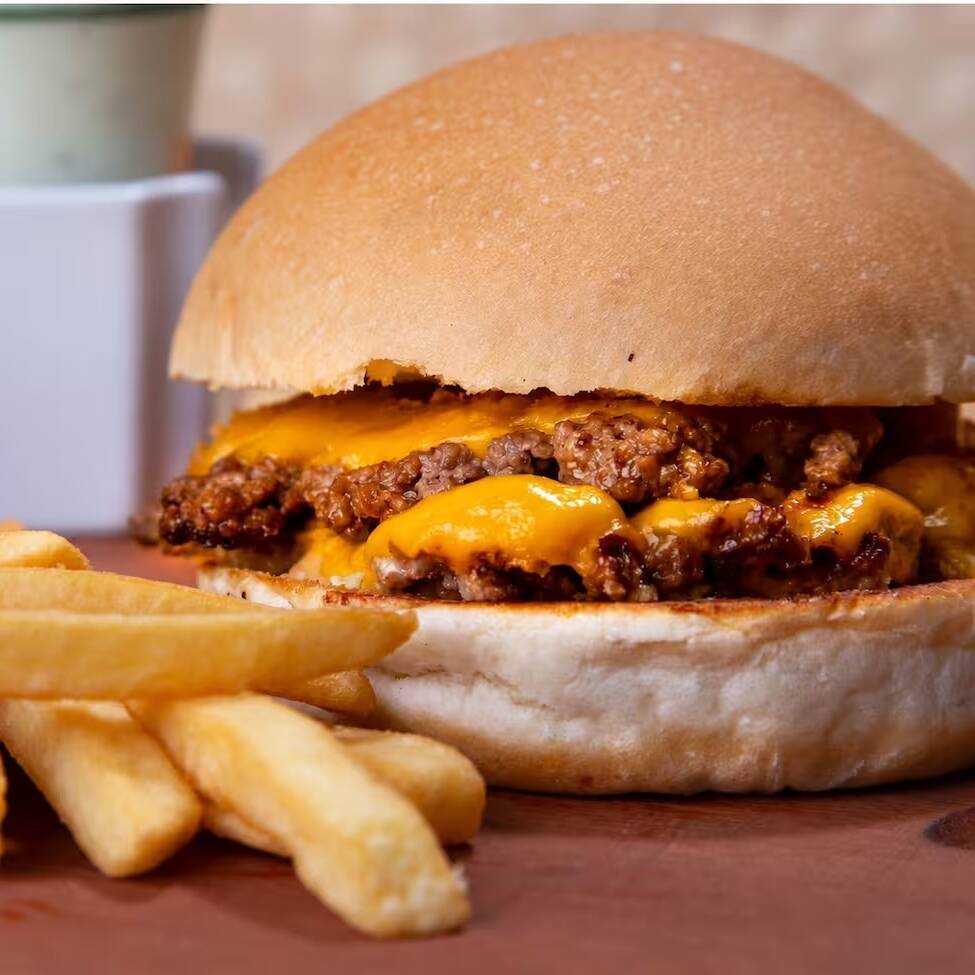 2 Carnes hambúrguer smash, Queijo Prato, Molho Tasty e Maionese Caseira. Acompanha fritas.