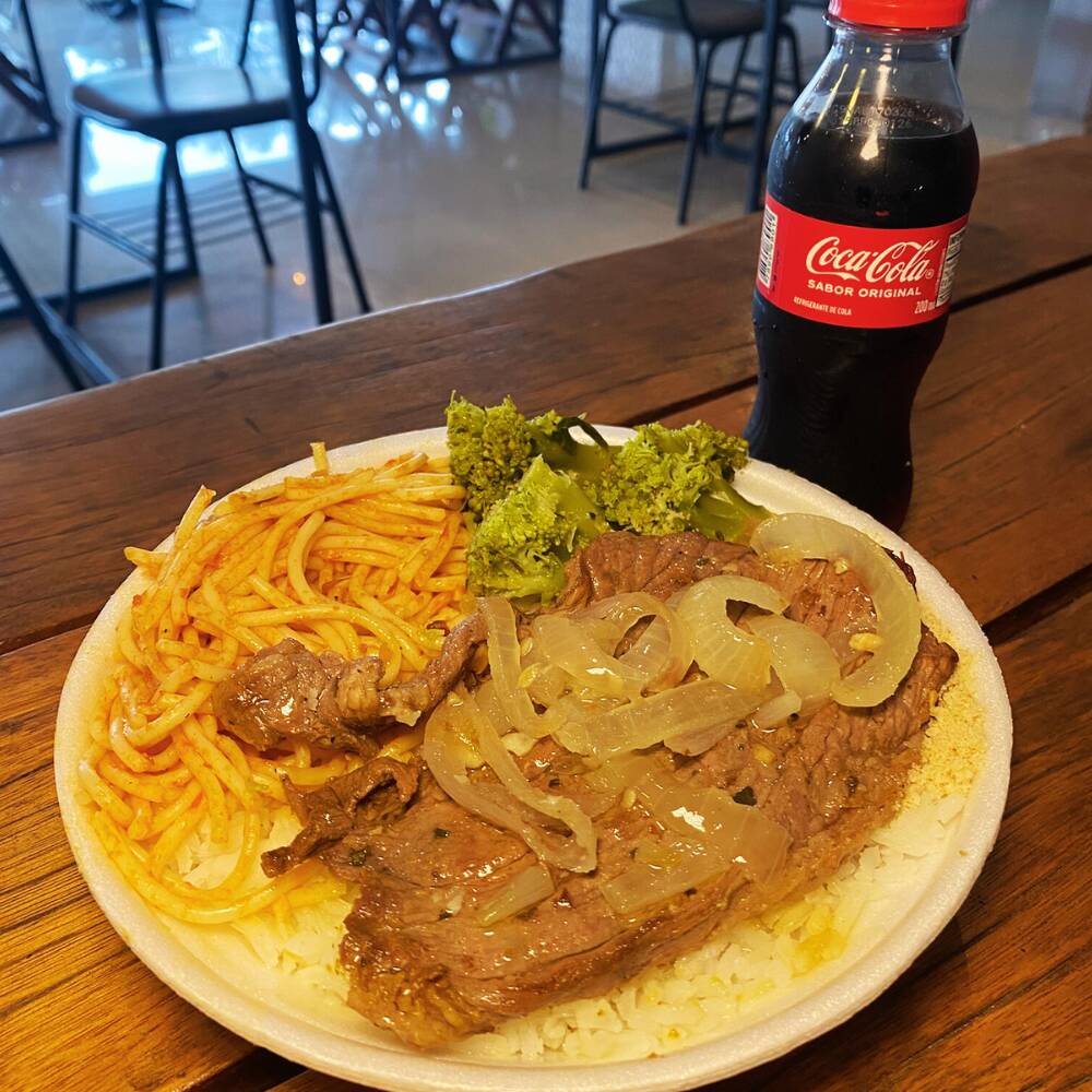 Marmita pequena de Bife bem temperado com aquela cebola que derrete na boca, do jeitinho que lembra comida de mãe. Acompanha arroz soltinho, feijão branco cremoso, farofa dourada, refogado saboroso, macarrão e saladinha fresca. Almoço completo, generoso e feito com amor.