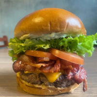 Pão De Hamburguer, alface lisa, tomate, hambúrguer 120g de fraldinha, bacon, queijo cheddar e maionese artesanal.