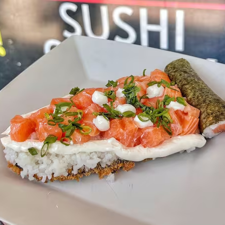 Uma base crocante de nori empanado, coberta com uma camada de Shari, nosso arroz preparado com perfeição, o salmão cru é selecionado e cortado com precisão para preservar todo o seu frescor e sabor.