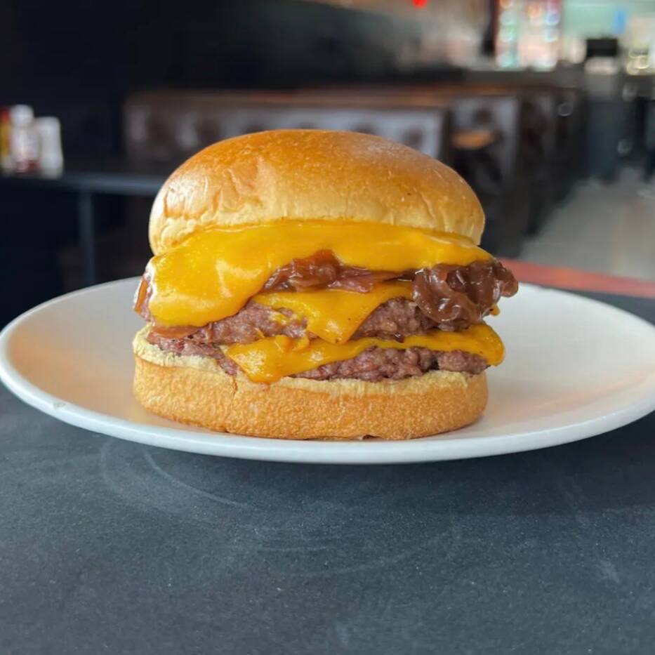 Pão brioche preparado com 2 carnes smash (60g cada) queijo cheddar em fatia, molho cheddar e cebola caramelizada.