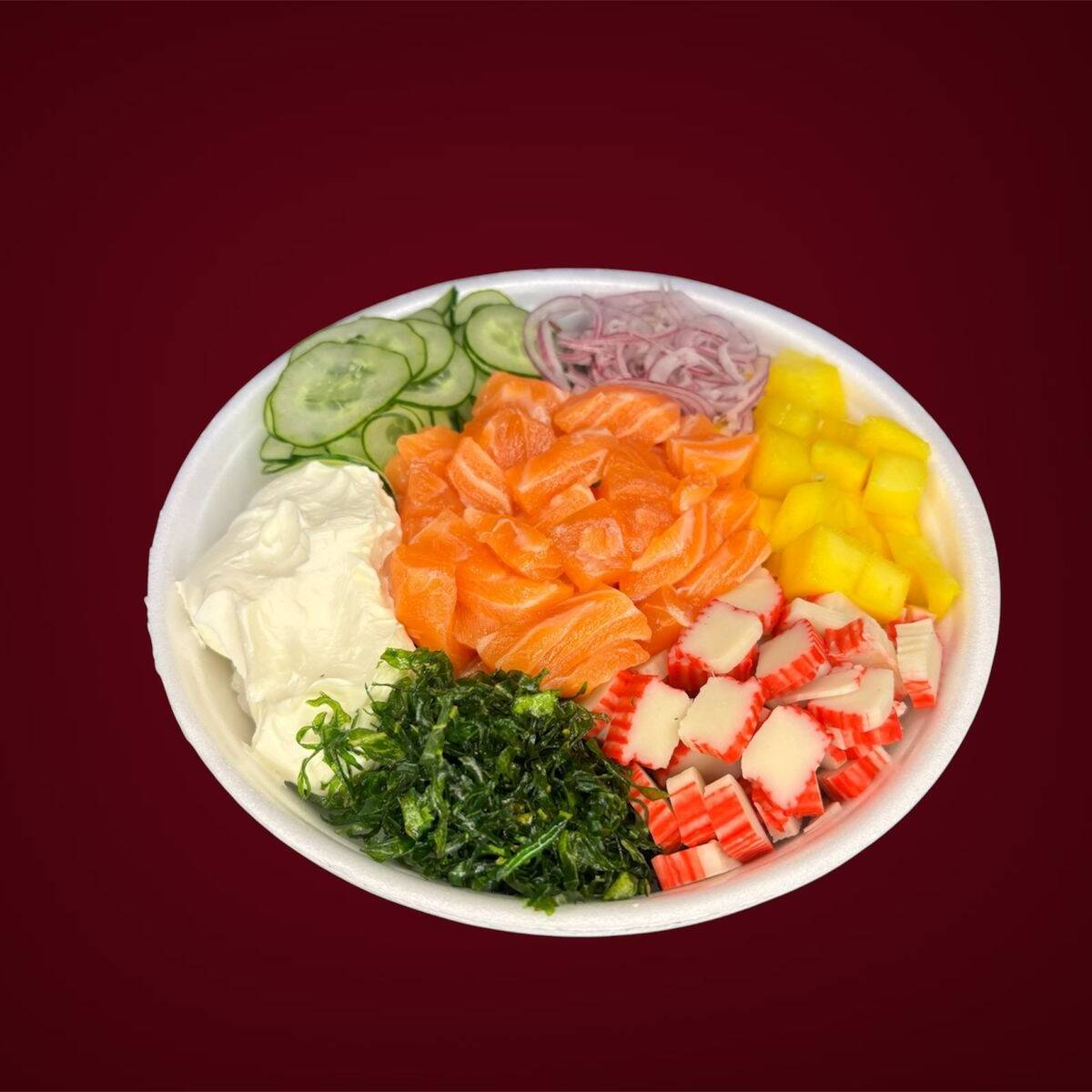 Poke saboroso com salmão em cubos, manga, pepino, kani, cebola roxa cream cheese e couve . Base de arroz japonês